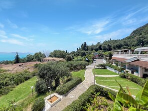 A residential area with terraced houses, a pathway, and a view of the sea. - Charming apartment in quaint Gastouri perfect for relaxing getaway (Gastouri)