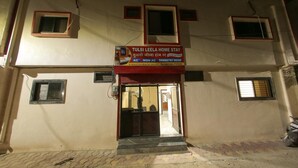 A two-story building with a sign for 'Tulsi Leela Home Stay' indicating a dormitory room. - Tulsi Leela - Home Stay (Dr. Ambedkar Nagar)