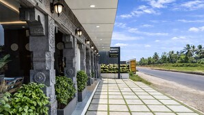 L'ingresso di un hotel con una tettoia, colonne in pietra e un cartello per Emmanuel Residency.
