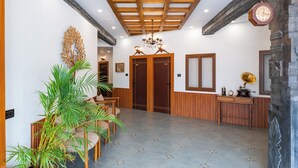 Un'area reception con soffitto in legno, un lampadario, una scrivania della reception e una sveglia.