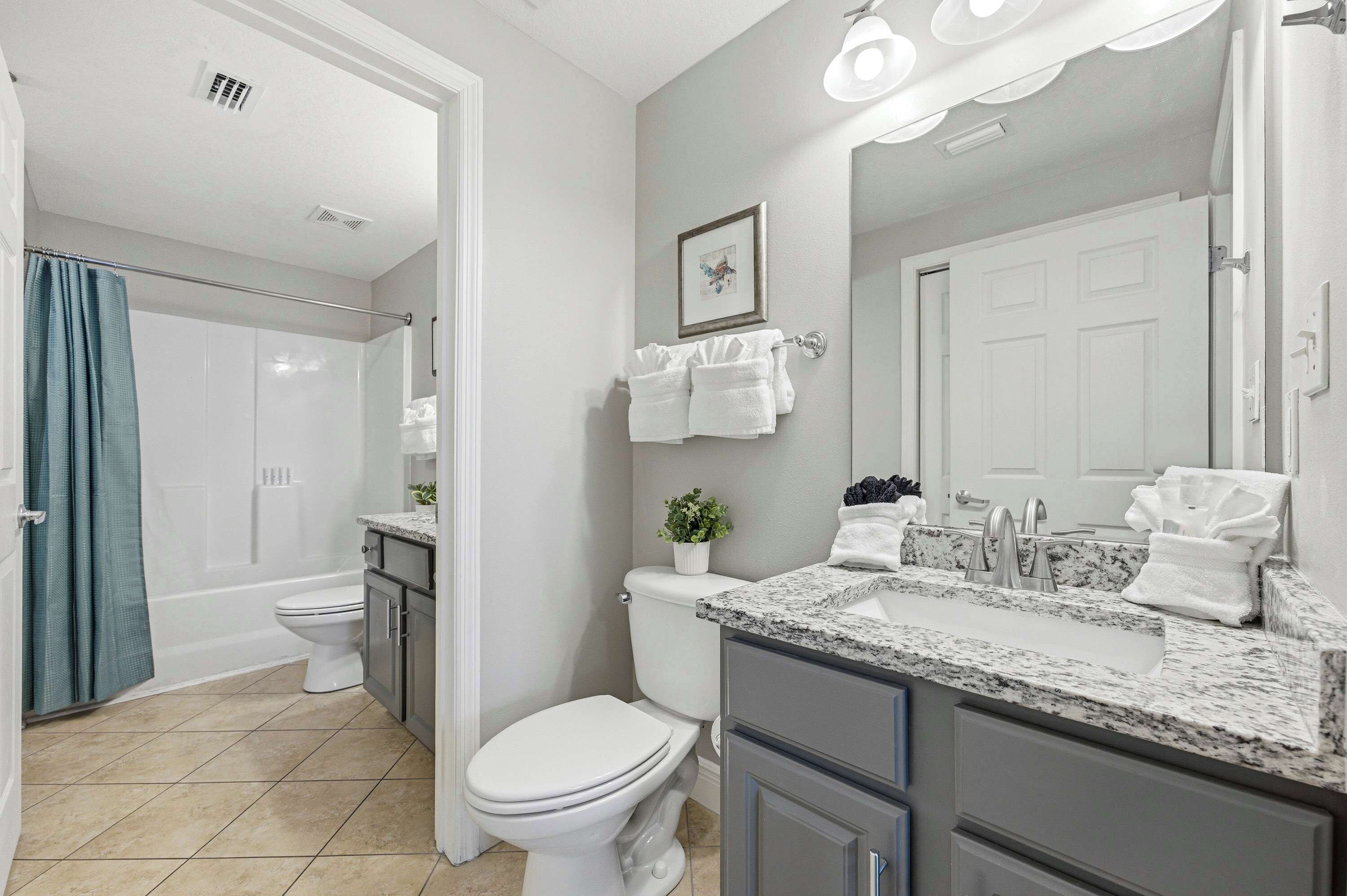 A bathroom with a toilet, sink, and shower.