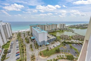 Ein Hochhaus-Hotel mit Parkplatz, einem Jachthafen und Blick auf den Strand.