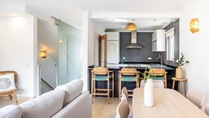 Una cocina moderna con comedor, que incluye una mesa de madera, sillas y un sofá.