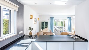 Una cocina moderna con comedor, sofá y vistas al exterior.