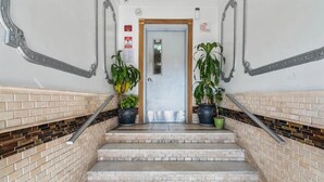 A staircase with brick walls, a metal railing, and potted plants. - FIFA World Cup Stay • Easy Transit to MetLife • Near NYC (Jersey City)
