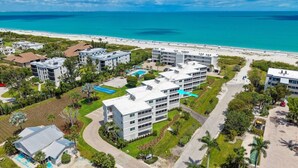 A coastal hotel with multiple buildings, a swimming pool, and a beach view. - Sanibel Surfside 234: Beautifully Updated with Gulf Views! 2 PB Courts! (Sanibel)