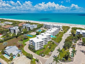 Ein Küstenhotel mit mehreren Gebäuden, einem Pool und Blick auf den Strand.