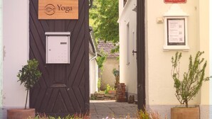 En smal gata med en trädörr märkt med ordet ”Yoga”, en skylt för en ”folkskola” och en anslagstavla med information.
