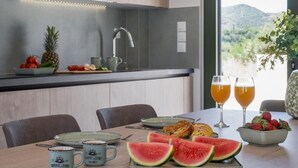 Une cuisine moderne avec vue sur l’extérieur, comprenant une table à manger dressée avec de la nourriture et des boissons.