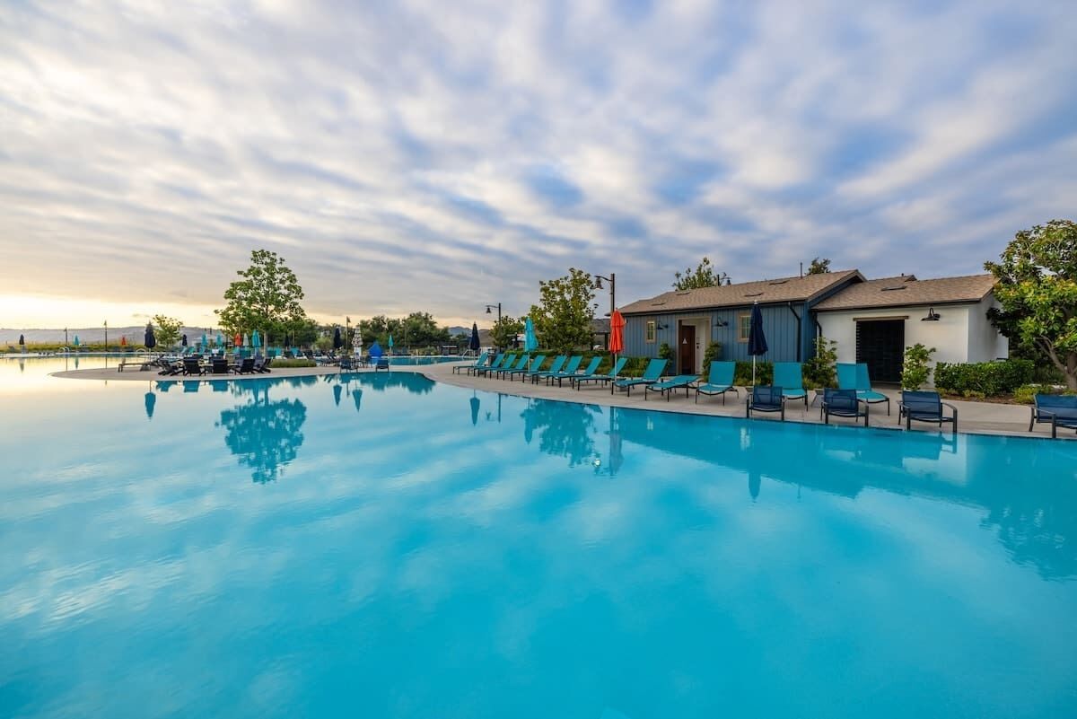 Una piscina al aire libre, sombrillas, tumbonas