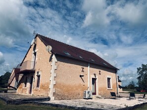 Um edifício com telhado inclinado, antenas parabólicas e um pequeno aparelho de ar condicionado.