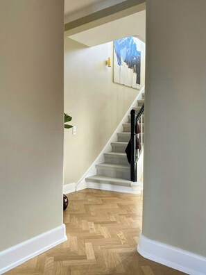 Ein Korridor, der zu einer Treppe führt, mit einem Gemälde an der Wand.