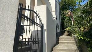 A residential building with a concrete staircase leading to a gated entrance. - Modern apartment with sea view in the old town of Crikvenica (Crikvenica)
