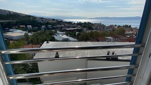 A balcony with metal railings overlooking a town and a body of water. - Modern apartment with sea view in the old town of Crikvenica (Crikvenica)