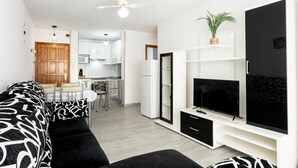 A compact living space with a sofa, TV, and a kitchenette. - Vacation Home 'Los Abrigos Sea View' with Ocean Views, Balcony and Wi-Fi (Los Abrigos)