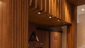 Un comptoir d’accueil avec un lambris vertical en bois et un éclairage encastré.