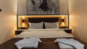 Une chambre d’hôtel avec un grand lit, des lampes de chevet et une œuvre d’art encadrée au mur.