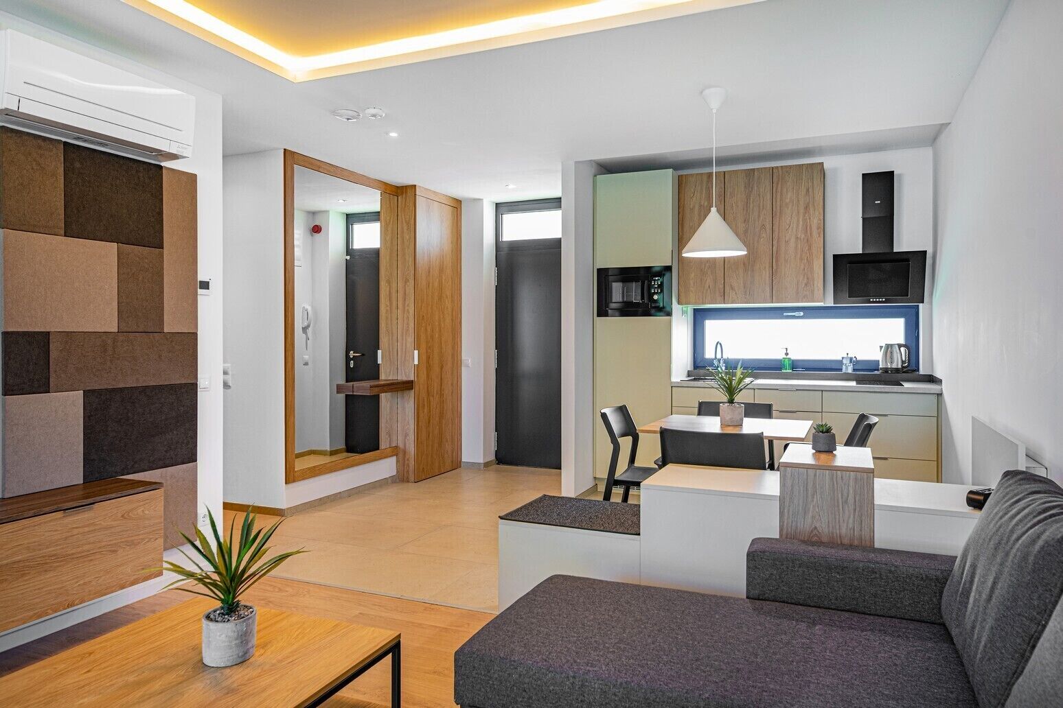 A modern living room with a sofa, a coffee table, and a dining area with chairs.