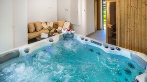 Un jacuzzi en una habitación con sofá y paredes de madera.