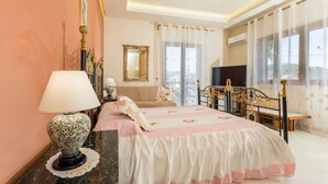 A bedroom with a bed, a bedside table with a lamp, a mirror, and a window with curtains. - Villa Marchese Bed and Breakfast – Deluxe with Balcony (Trecastagni)