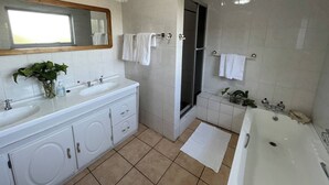A bathroom with a sink, mirror, towel rack, shower, and bathtub. - Room-luxury Stay in Pretoria! Fast Wi-fi (Pretoria)