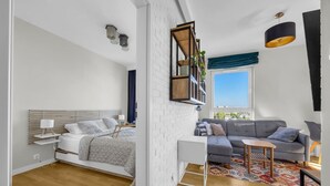 A modern bedroom with a bed, bedside table, and a nightstand. - Praga Apt - 57m2, Parking, Balcony - by Rentujemy (Warszawa)