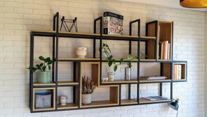 A wall-mounted shelving unit with various decorative items and books. - Praga Apt - 57m2, Parking, Balcony - by Rentujemy (Warszawa)