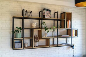 A wall-mounted shelving unit with various decorative items and books.