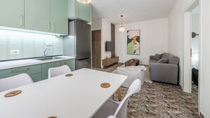 A compact living space with a kitchen, dining area, and a gray sofa.