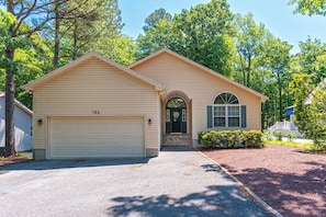 A two-story house with a garage, a front entrance with a door, and a driveway.