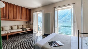 Un dormitorio con cama, un banco de madera, vistas al mar y un suelo estampado.