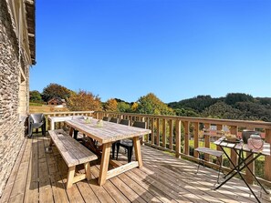 A wooden deck with a table and chairs, a bench, and a small table with items on it. - Breathtaking view with jacuzzi & sauna in the most beautiful region of the Ardennes (Vresse-sur-Semois)
