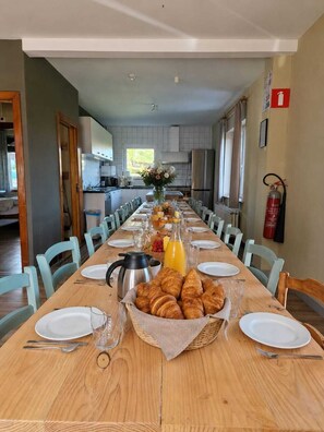 A dining area with a long table set for breakfast, including croissants and orange juice. - Breathtaking view with jacuzzi & sauna in the most beautiful region of the Ardennes (Vresse-sur-Semois)