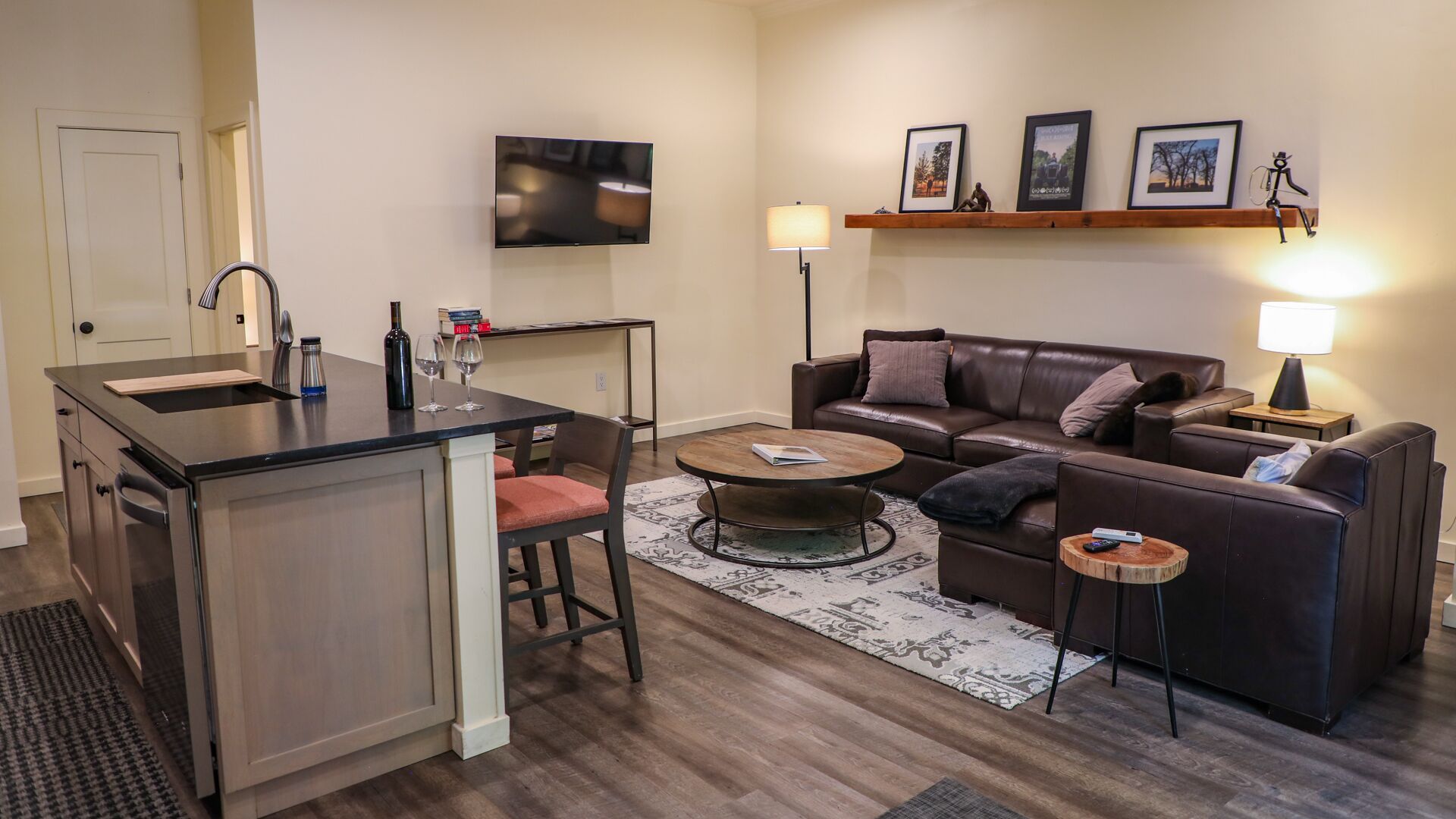 A modern apartment with a kitchen, living area, and a dining table.