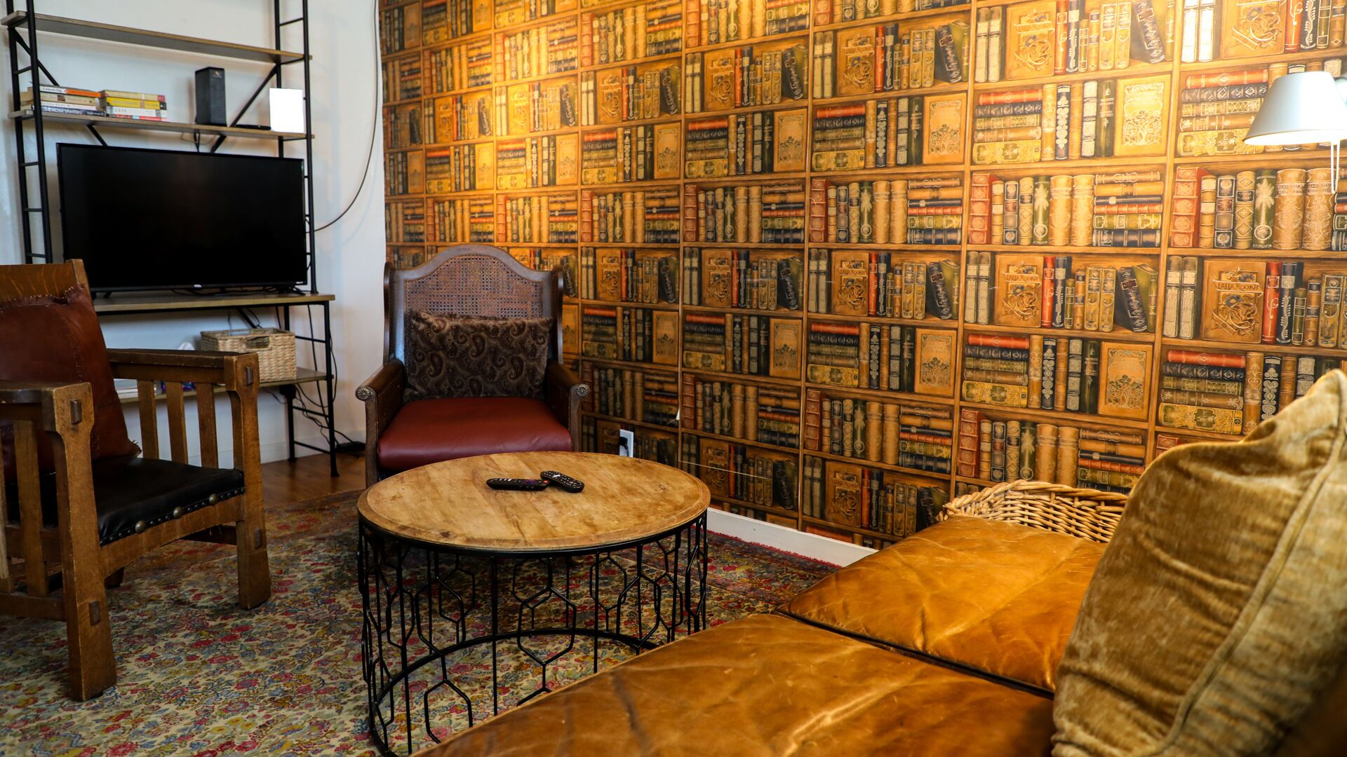 A cozy living room with a bookshelf, a television, and a comfortable seating area.