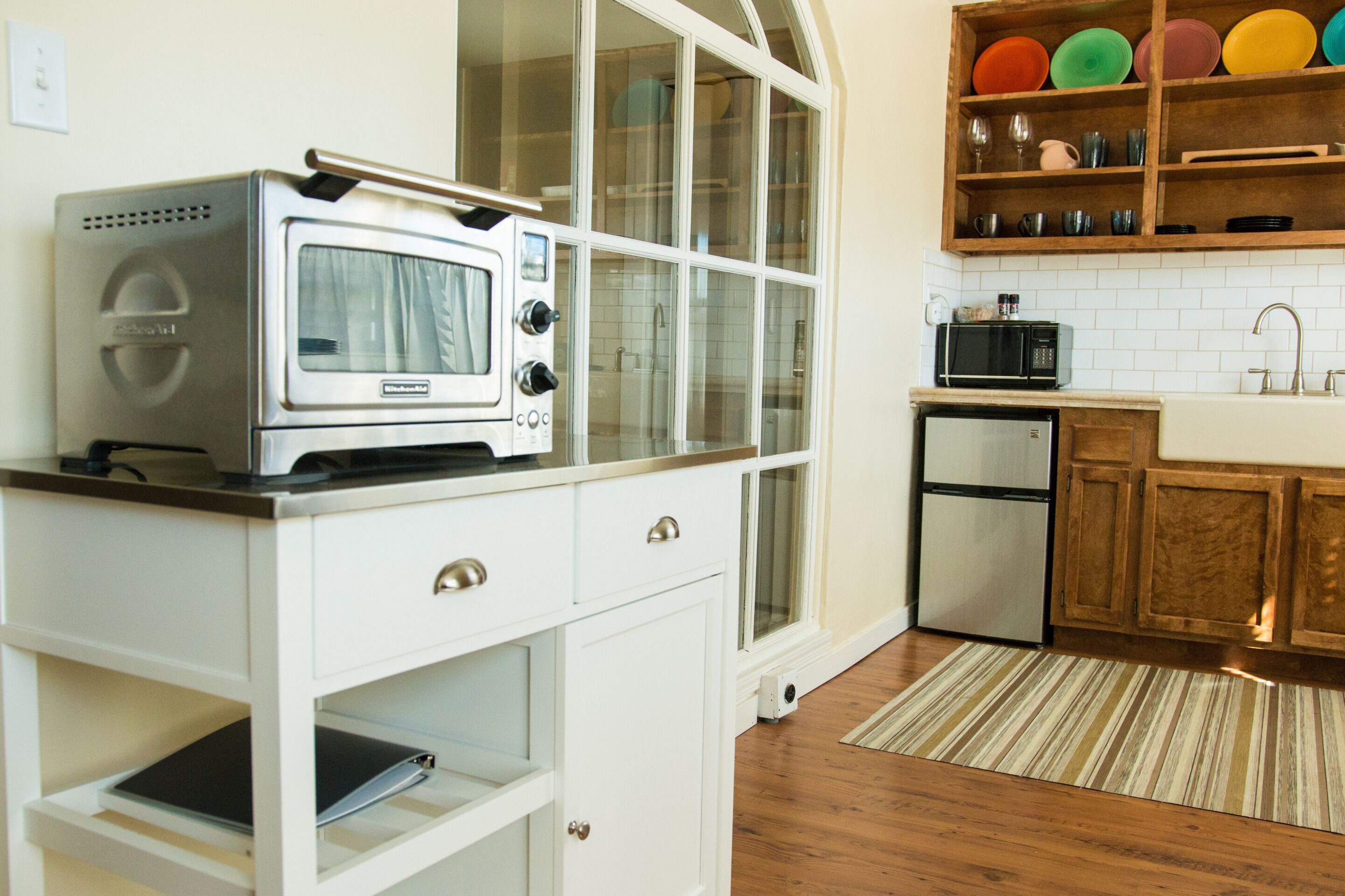 A kitchen with a built-in microwave, a toaster, and a refrigerator.