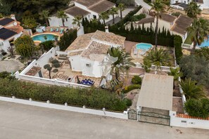 Ein Wohnhaus mit Swimmingpool, mehreren Zimmern und einem eingezäunten Garten.