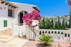 A coastal property with a white stucco exterior, a balcony with a white balustrade, and a view of the sea and a hillside town. - CostaBlancaDreams - Villa Orquidia in Benissa (Benissa)