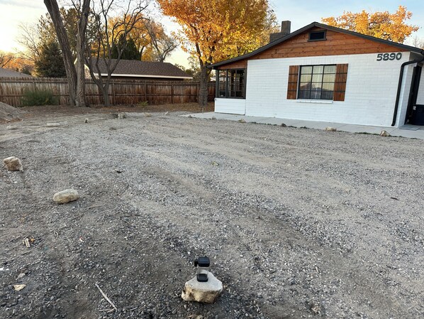A gravel driveway leading to a white building with the number 5890.