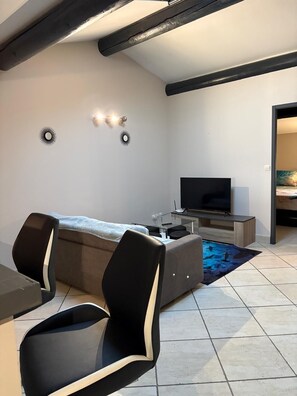 A modern living room with a sofa, two chairs, a TV, and a coffee table. - Beautiful apartment with pool access (La Rouvière)