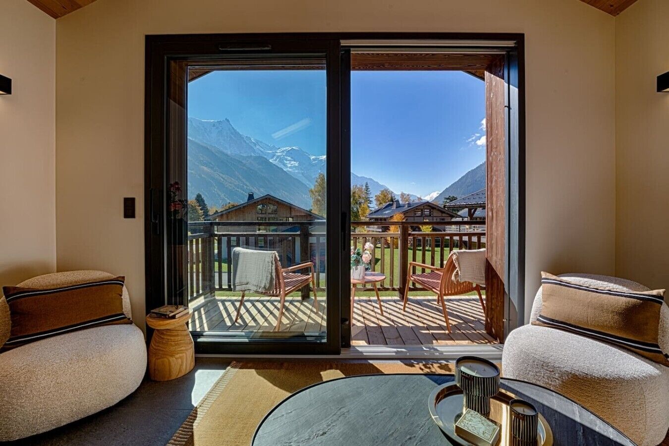 Une pièce dotée d’une porte-fenêtre coulissante donnant sur une terrasse extérieure avec des chaises et une table.