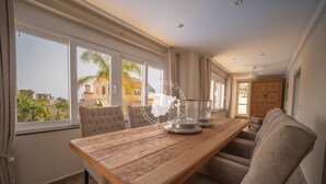 Una habitación amplia con una gran mesa de madera, asientos cómodos y ventanas grandes con vistas a la ciudad.