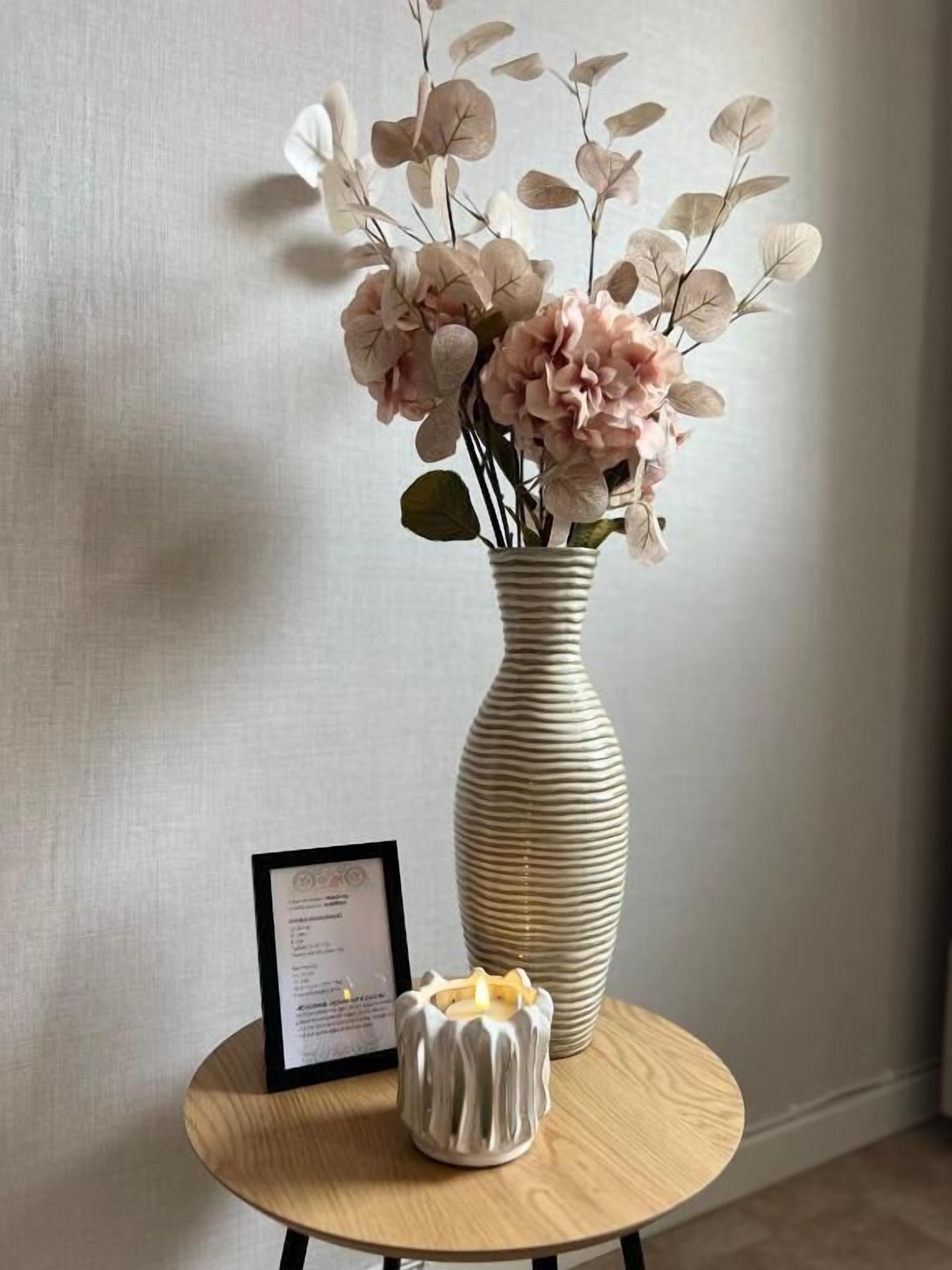 A vase with flowers on a round table.