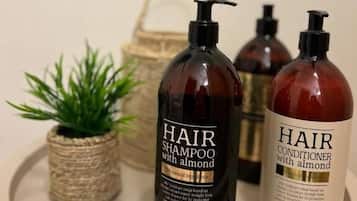 Tres botellas de productos para el cuidado del cabello sobre una mesa redonda.