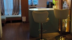 A modern kitchen with a central island, bar stools, and a view of the city.