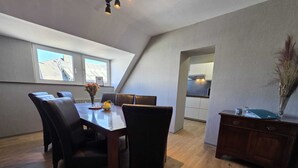 A dining area with a table, chairs, and a vase of flowers. - Eifel Pearl Manderscheid 2 (Manderscheid)