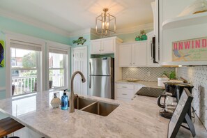 A kitchen with a stainless steel refrigerator, double sink, and a coffee maker. - Walk to Beach! Water-view Home in Gulf Shores (Gulf Shores)
