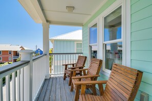 A wooden deck with chairs, a railing, and a view of neighboring houses. - Walk to Beach! Water-view Home in Gulf Shores (Gulf Shores)