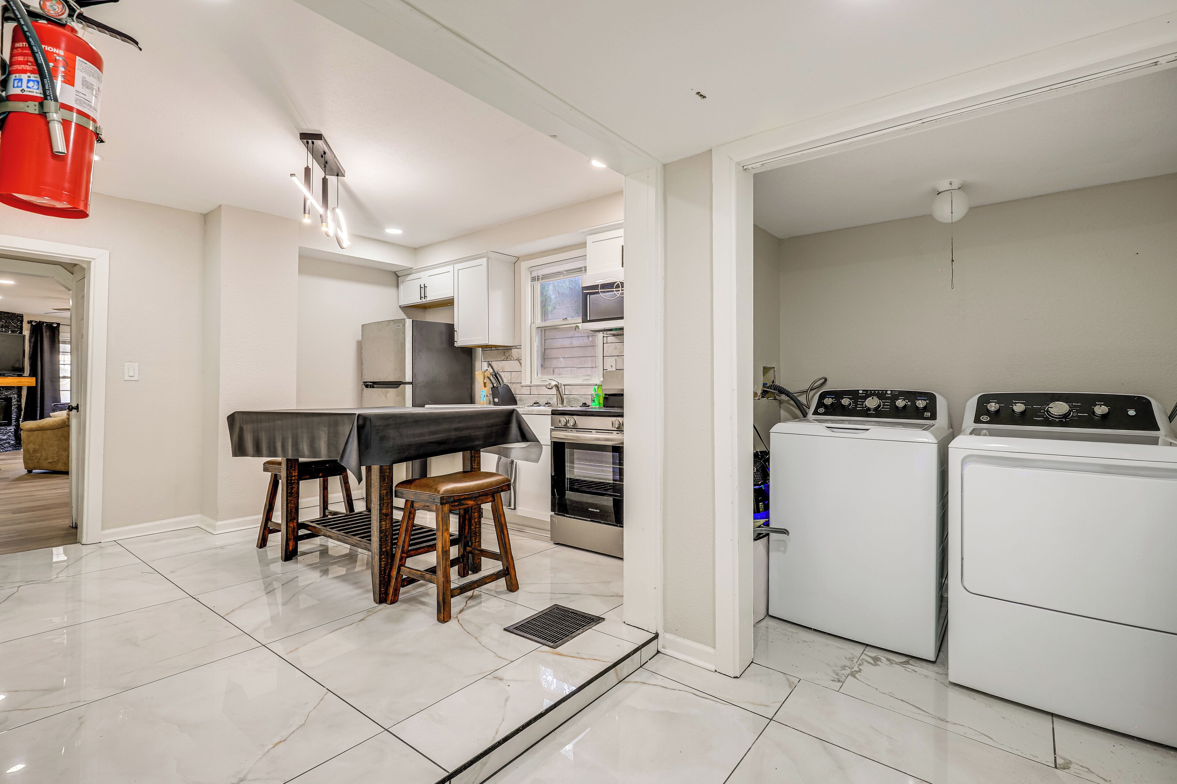 A modern kitchen with a dining area, a stove, oven, and two washing machines.
