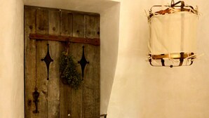 A wooden door with a metal gate, a hanging plant, and a white cloth hanging from the ceiling. - Au Canari, a former bar-tabac transformed into a charming gîte in the village of Colette. (Saint-Sauveur-en-Puisaye)